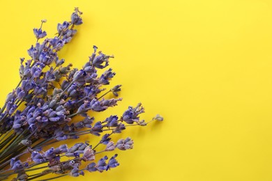 Photo of Beautiful lavender flowers on yellow background, top view. Space for text