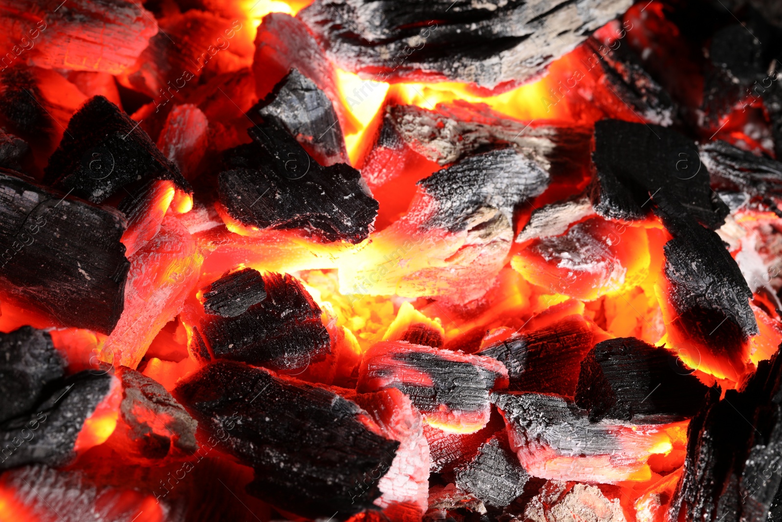 Photo of Pieces of hot smoldering coal as background, closeup