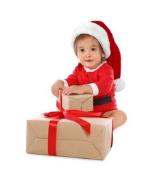 Festively dressed baby with gift boxes on white background. Christmas celebration