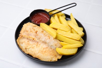 Delicious fish and chips with ketchup on white tiled table, closeup