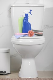 Cleaning supplies on toilet bowl in bathroom