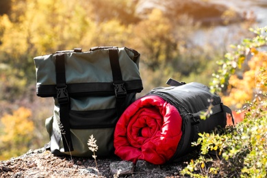 Photo of Backpack and sleeping bag on ground outdoors. Camping equipment