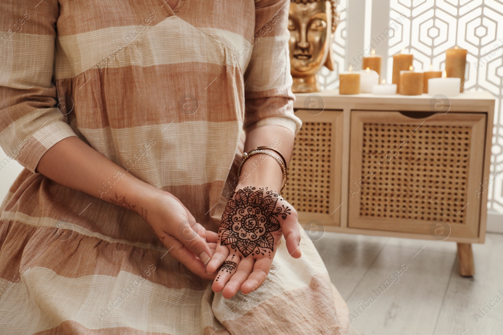 Photo of Woman with henna tattoo on palm indoors, closeup and space for text. Traditional mehndi ornament