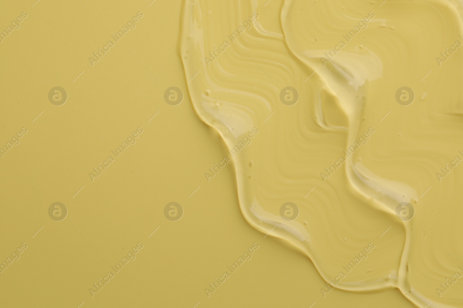 Photo of Clear cosmetic gel on yellow background, top view. Space for text