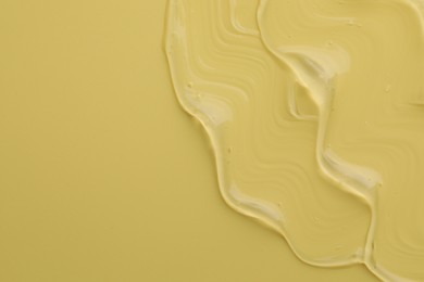 Clear cosmetic gel on yellow background, top view. Space for text