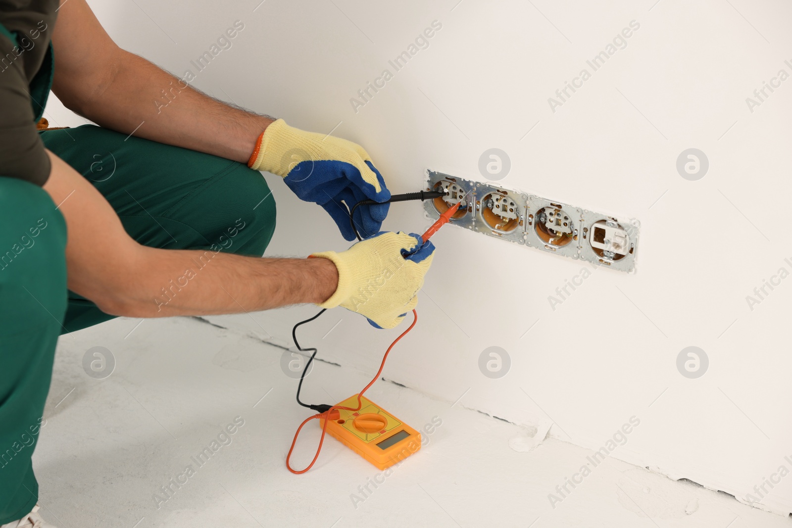 Photo of Electrician with tester checking voltage indoors, closeup