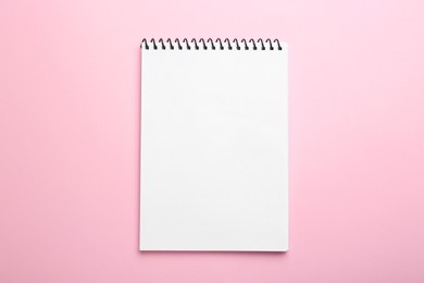 Photo of One notebook on pink background, top view. Space for text