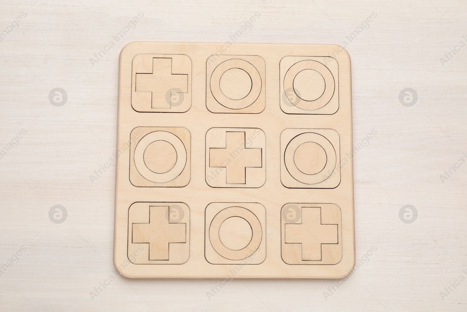 Photo of Tic tac toe set on white wooden table, top view