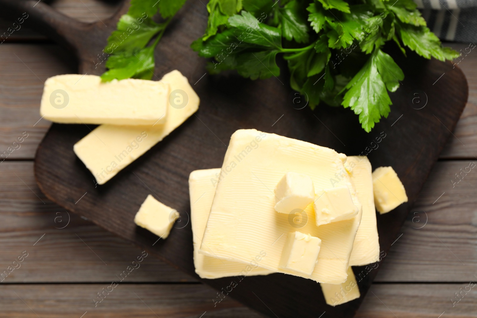 Photo of Tasty butter and parsley on wooden table, top view