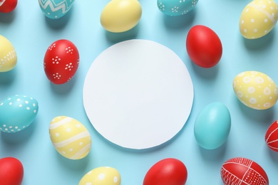Photo of Flat lay composition of painted Easter eggs and card on color background, space for text
