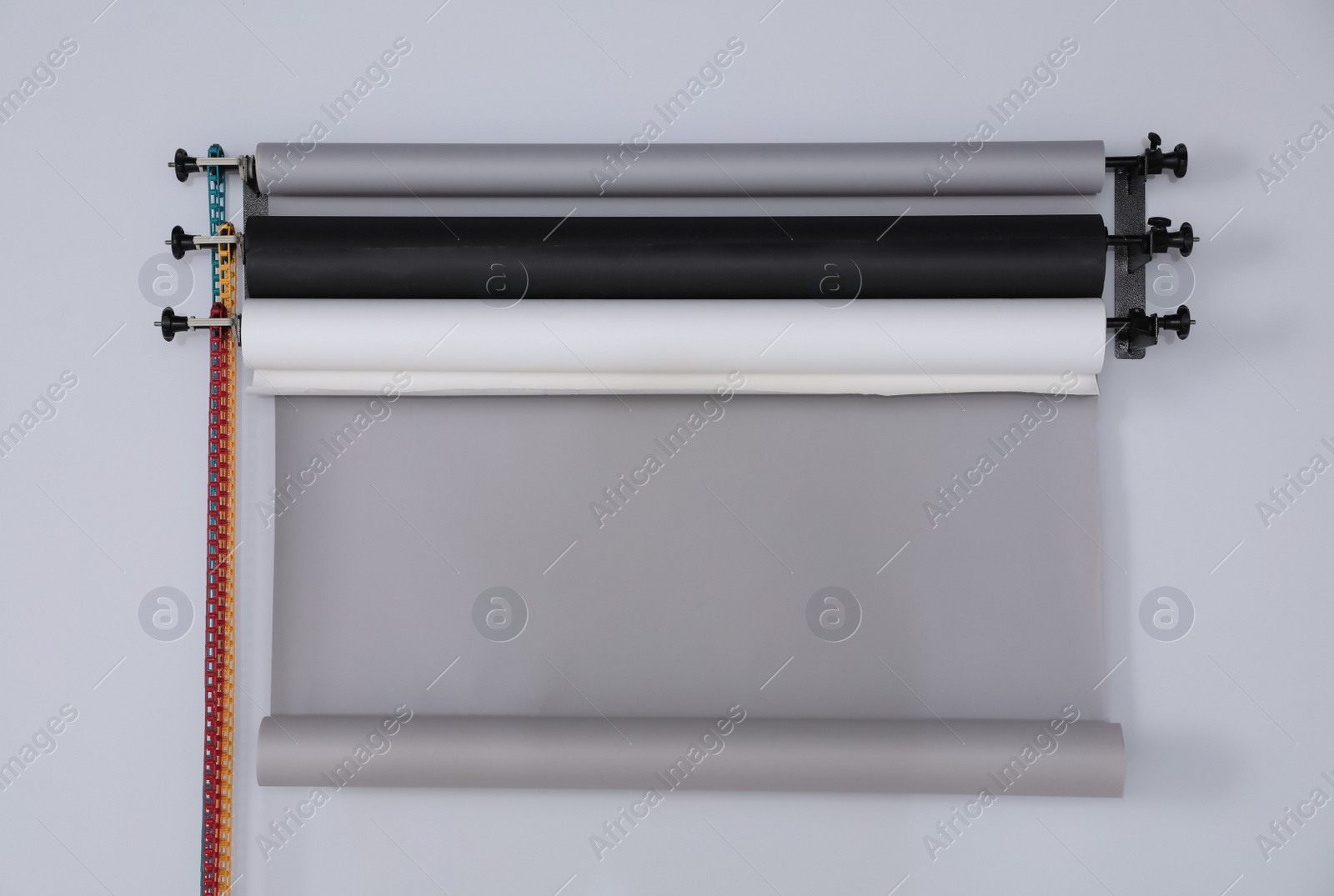 Photo of Colorful photo background rolls on white wall in studio