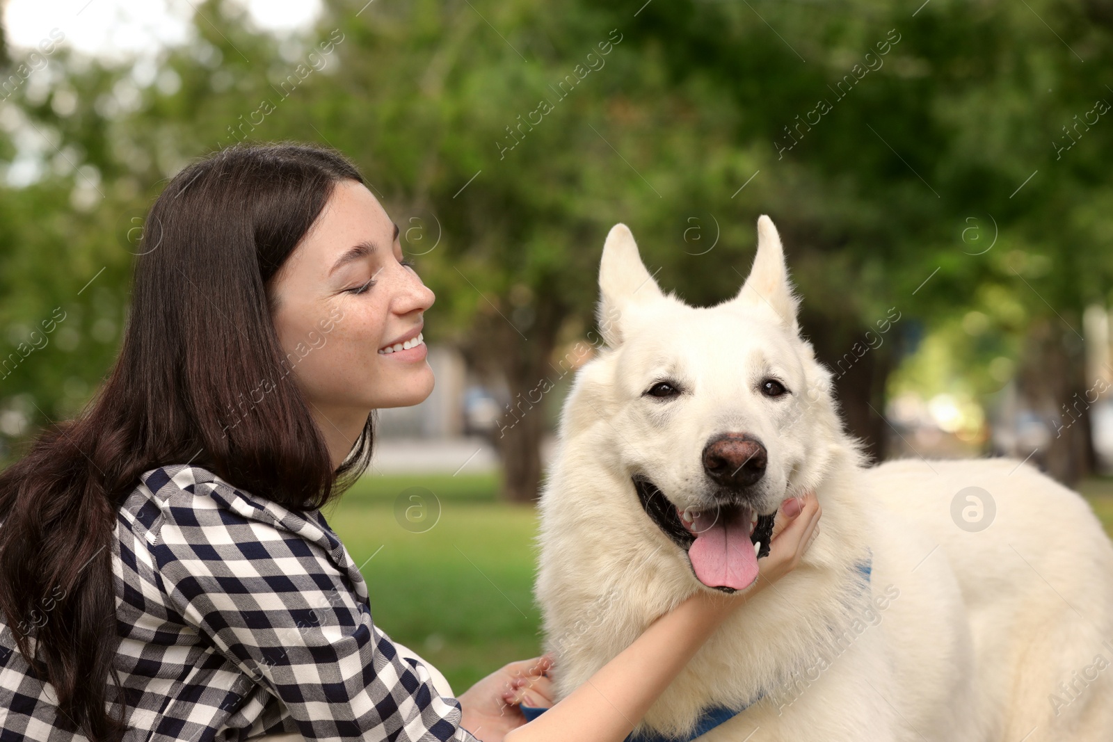 Photo of Teenage girl with her white Swiss Shepherd dog in park