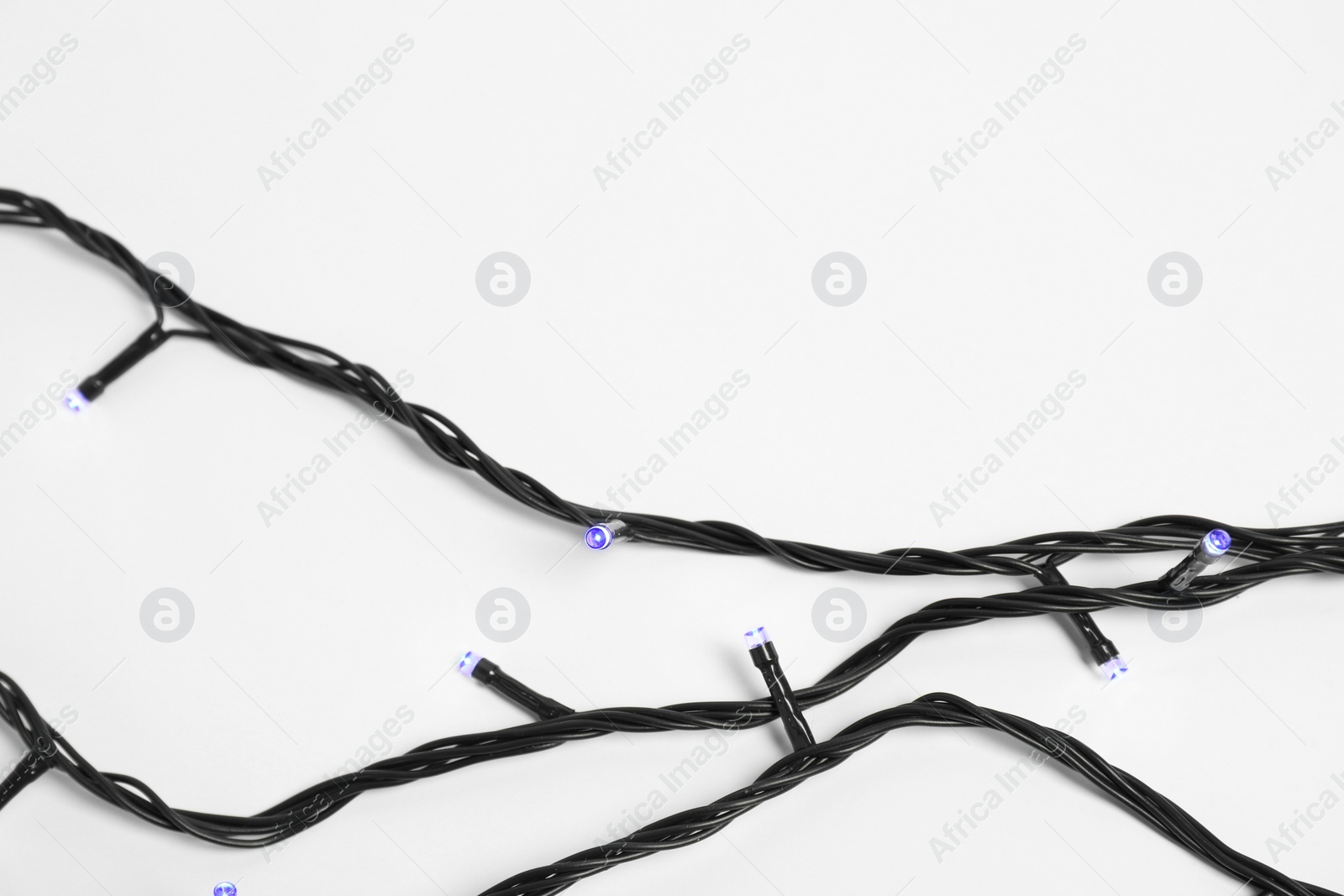 Photo of Beautiful Christmas lights on white background, top view