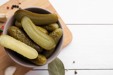 Photo of Tasty pickled cucumbers and ingredients on white wooden table, flat lay. Space for text