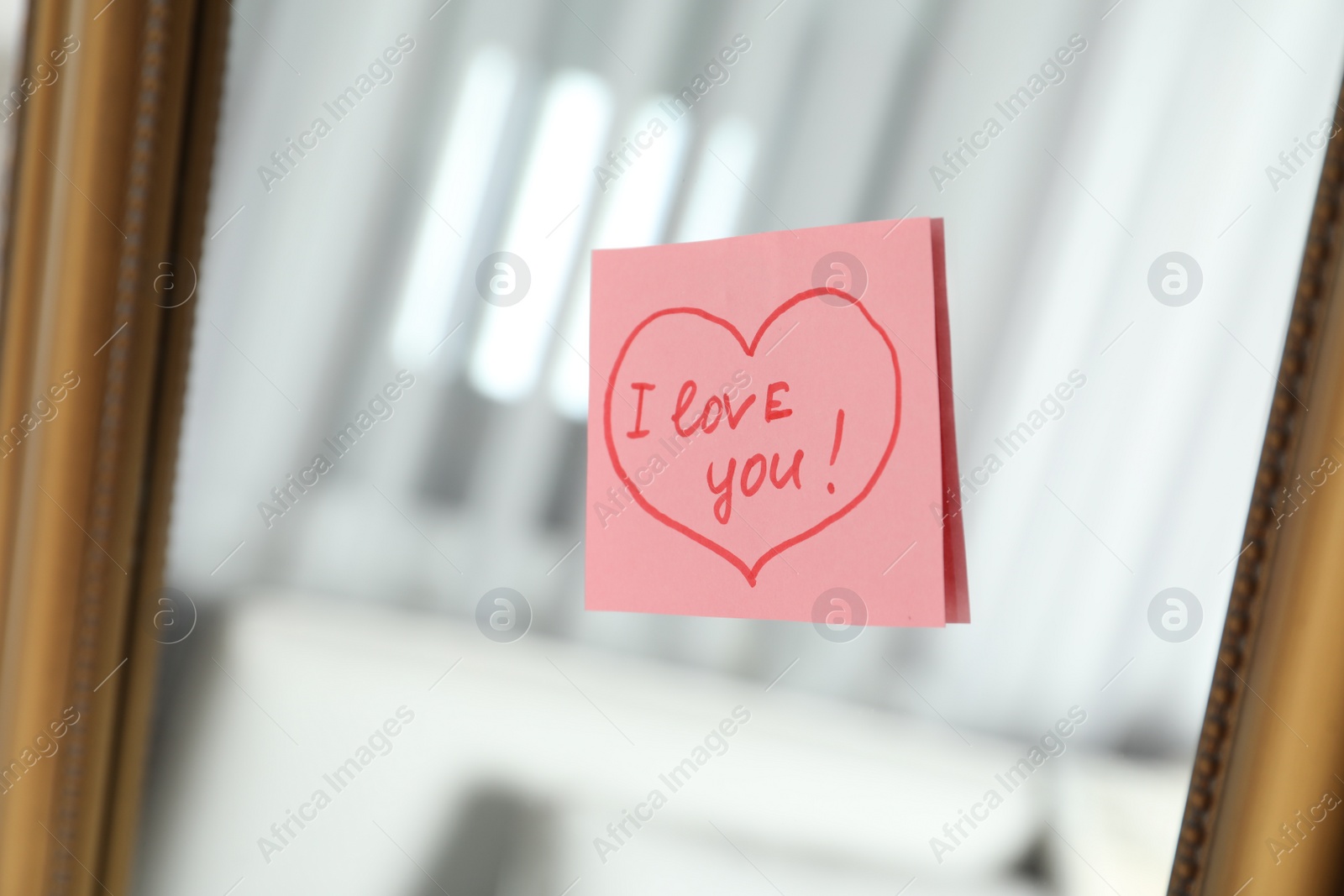 Photo of Note with phrase I Love You attached to mirror