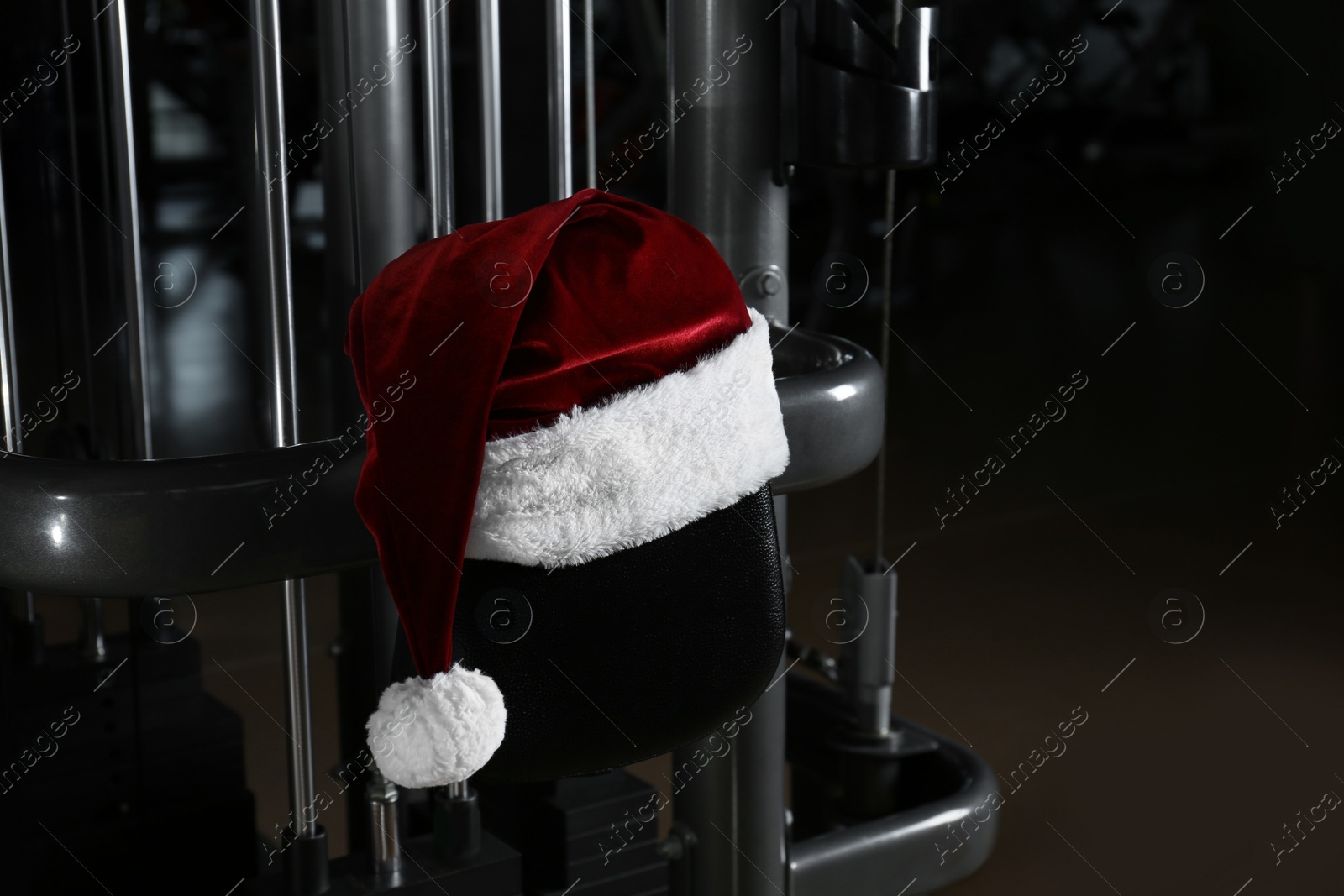 Photo of Santa hat on fitness machine in modern gym