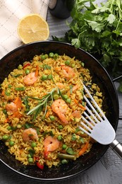 Photo of Tasty rice with shrimps and vegetables served on grey table, flat lay