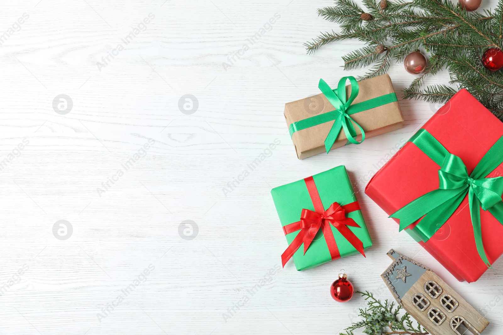 Photo of Flat lay composition with Christmas gift boxes on white wooden background. Space for text