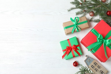 Photo of Flat lay composition with Christmas gift boxes on white wooden background. Space for text