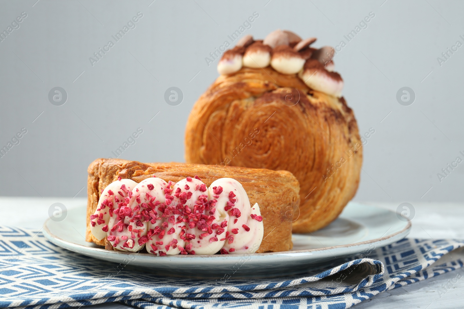 Photo of Crunchy round croissants on light table, closeup. Tasty puff pastry