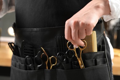 Photo of Hairstylist with professional tools in waist pouch, closeup