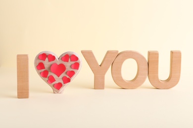 Photo of Phrase I Love You made of wooden letters on light background