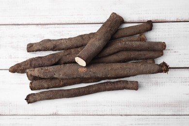 Photo of Raw salsify roots on white wooden table, flat lay