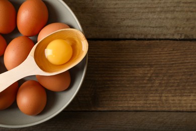 Raw chicken eggs on wooden table, top view. Space for text