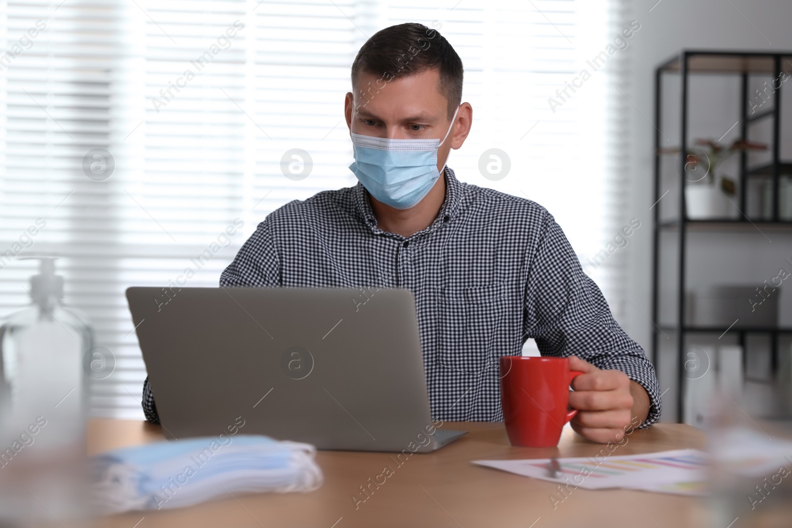 Photo of Worker with mask in office. Protective measure during COVID-19 pandemic