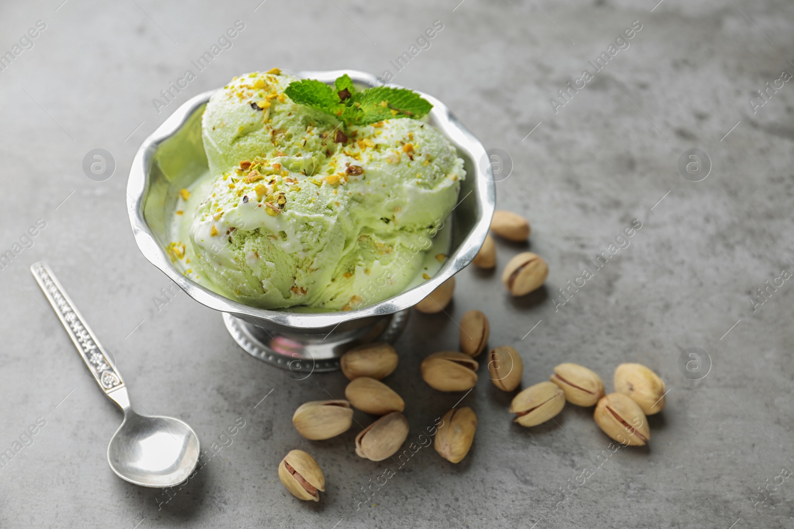 Photo of Delicious pistachio ice cream on grey table