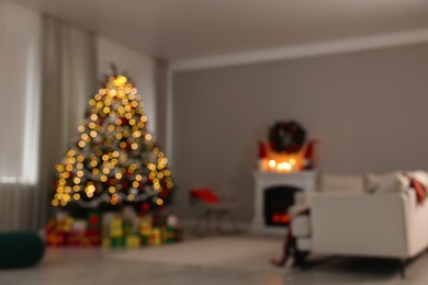 Blurred view of beautiful Christmas tree in stylish living room interior. Bokeh effect