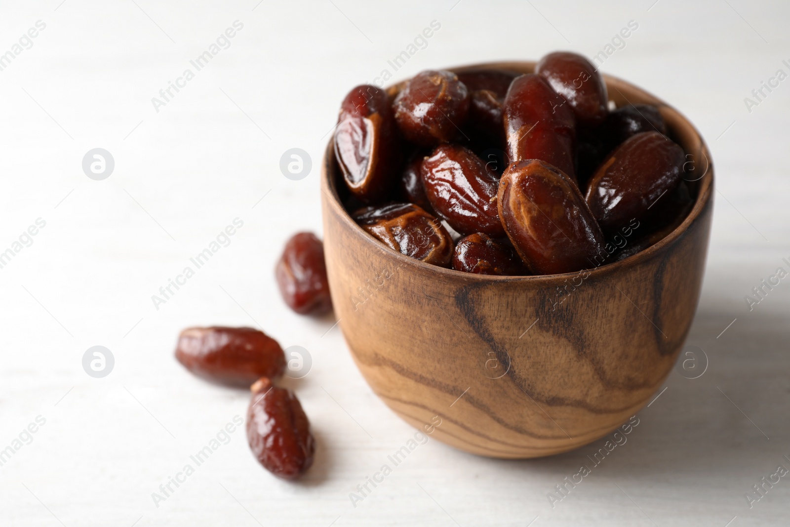 Photo of Bowl with sweet dates on table, space for text. Dried fruit as healthy snack