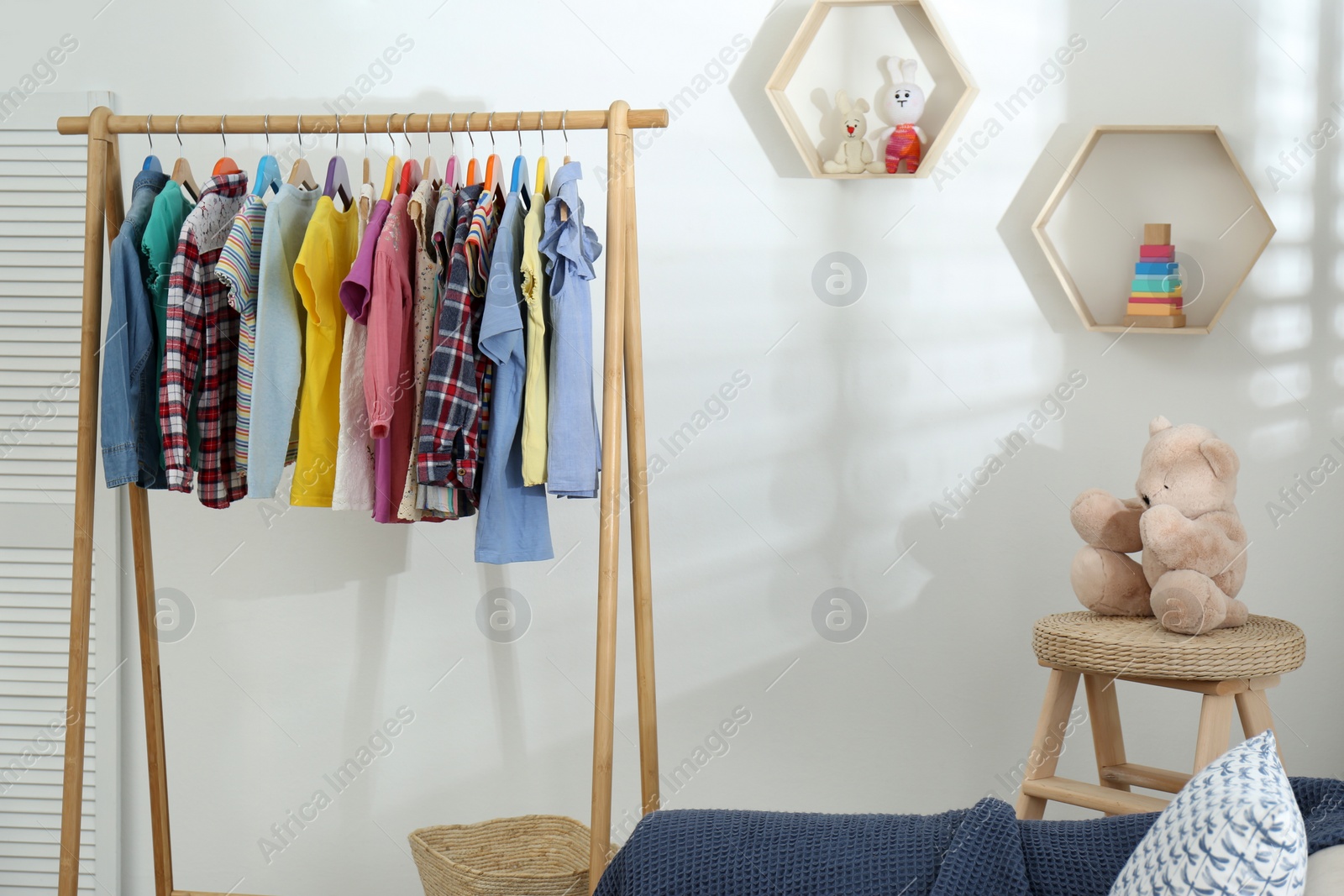 Photo of Different child's clothes hanging on rack in room