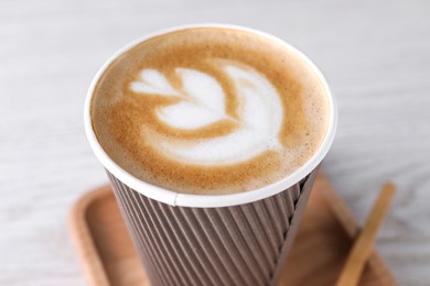 Photo of Coffee to go. Paper cup with tasty drink on white table, closeup