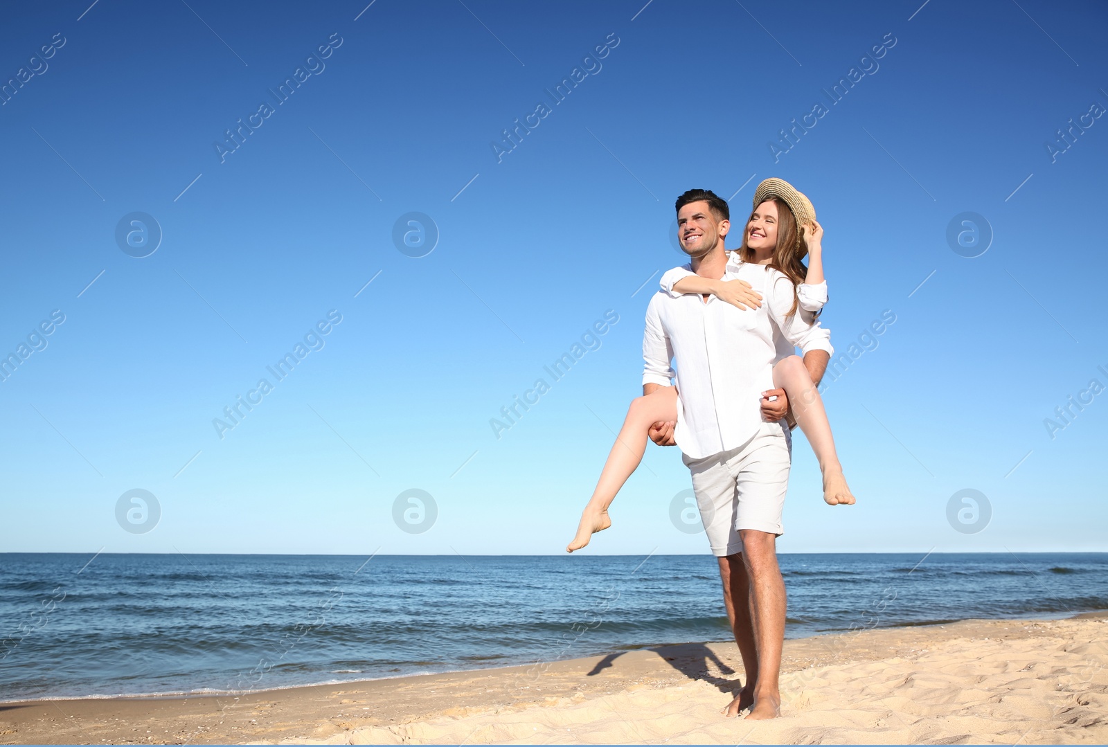 Photo of Lovely couple spending time together on beach. Space for text