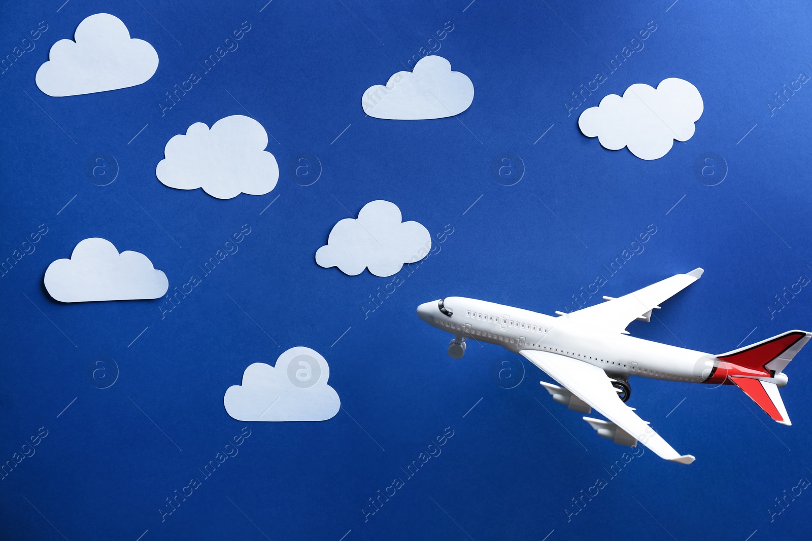 Photo of Toy airplane against blue background with clouds