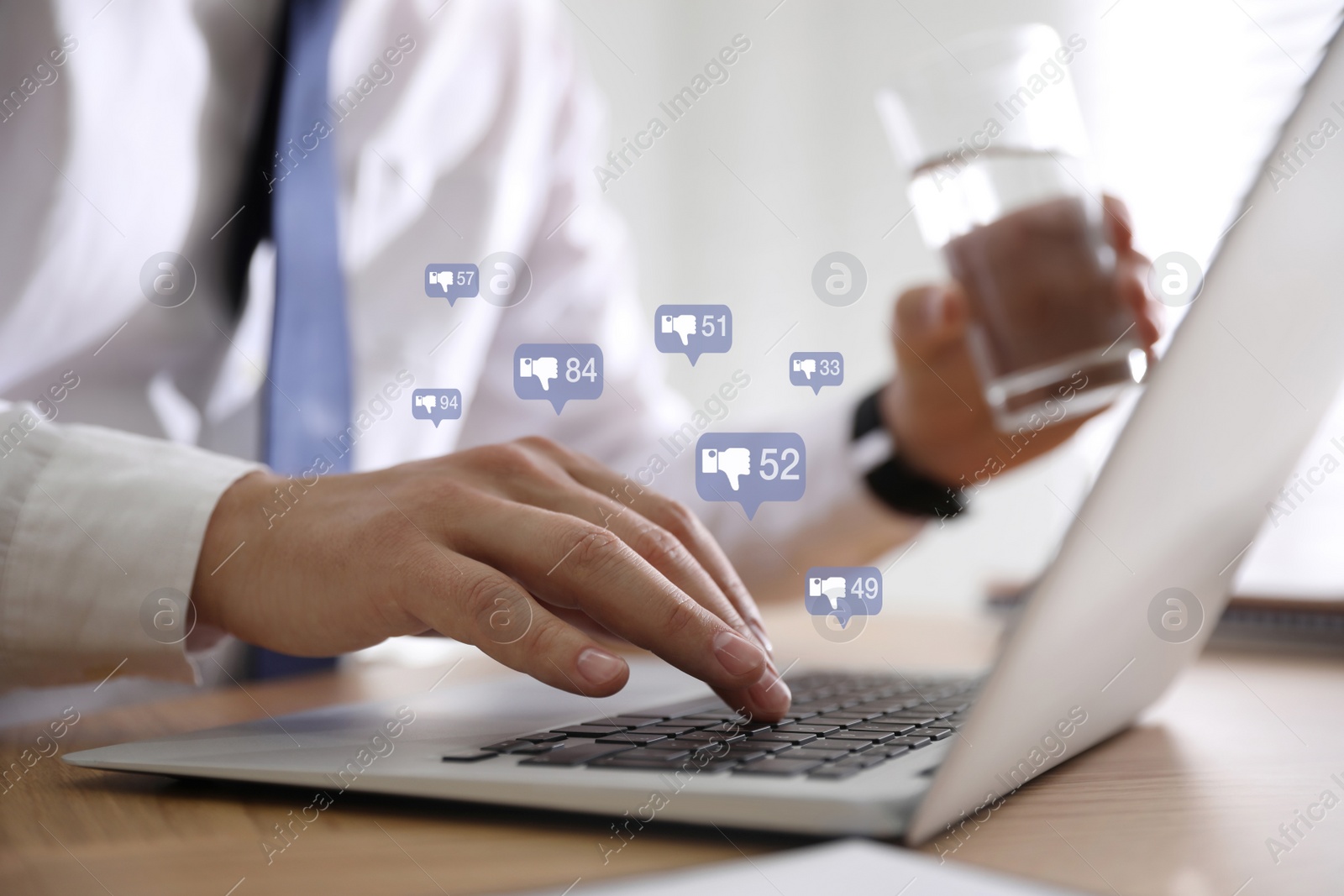 Image of Closeup view of young man using modern laptop at wooden table. Cyberbullying concept