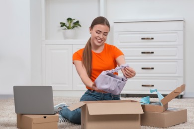 Happy woman unpacking parcels at home. Online store