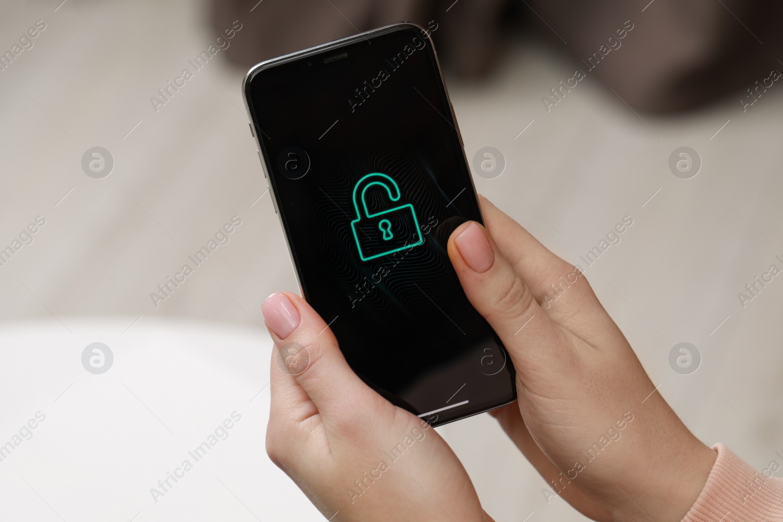 Photo of Woman holding smartphone with blocked screen indoors, closeup