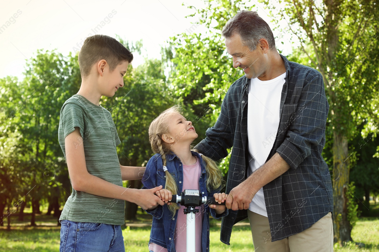 Photo of Male pensioner with grandchildren in park on sunny day