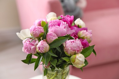 Photo of Vase with bouquet of beautiful peonies in room