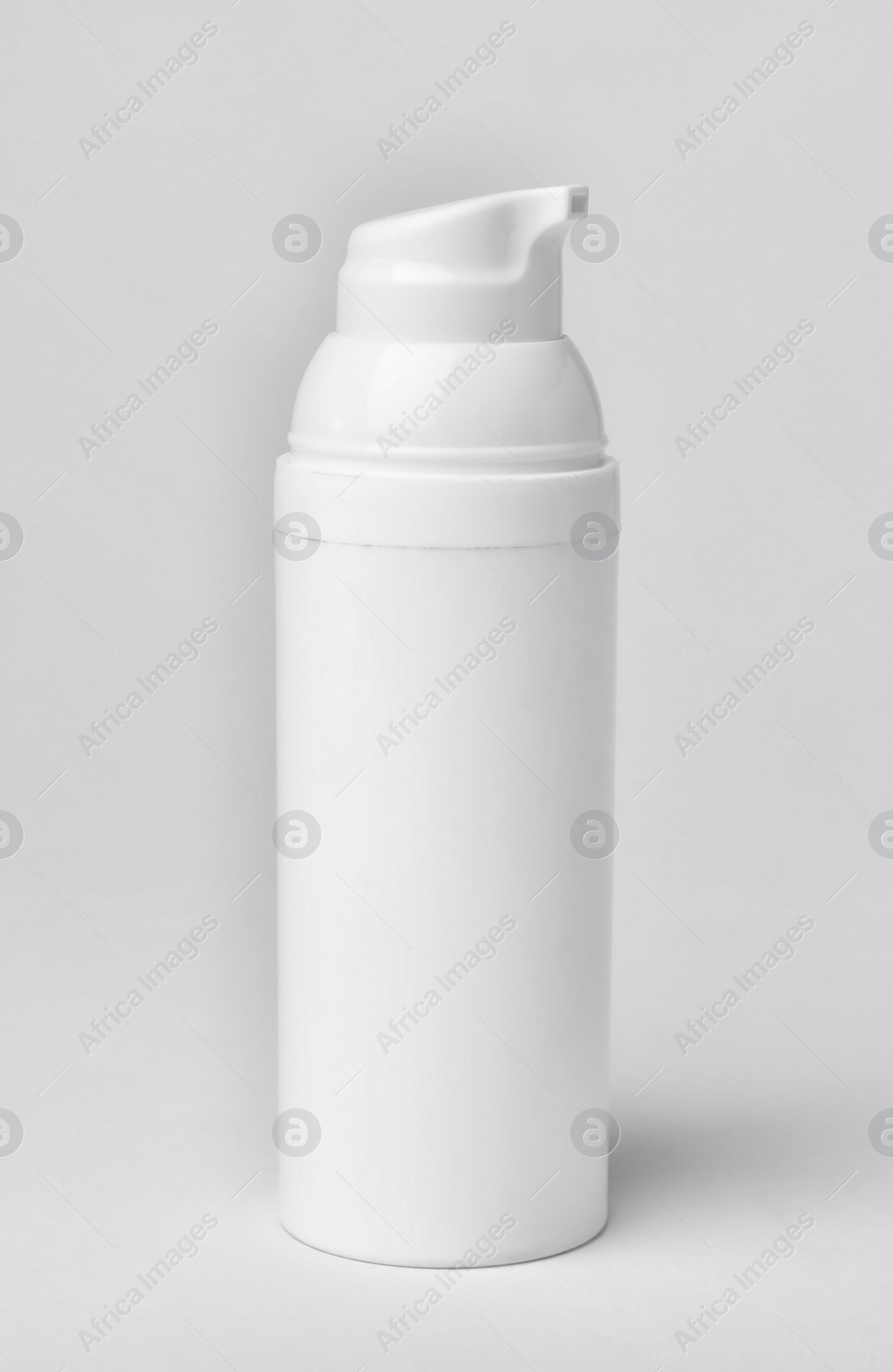 Photo of Bottle of cosmetic product on light background