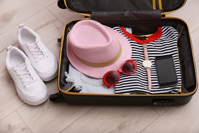 Photo of Packed suitcase on wooden background. Summer vacation