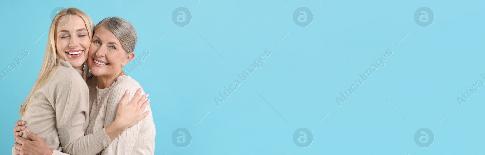 Image of Happy mother and daughter on light blue background, space for text. Banner design