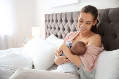 Photo of Young woman breastfeeding her baby in bedroom