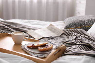 Photo of Morning coffee and sandwiches on tray in bedroom