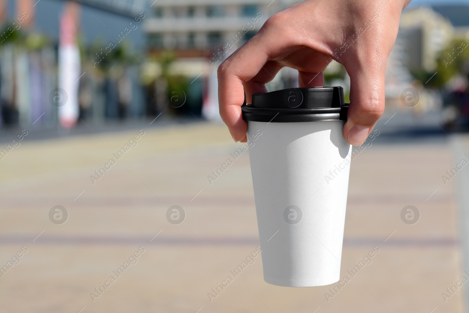 Photo of Woman holding takeaway coffee cup outdoors, closeup. Space for text