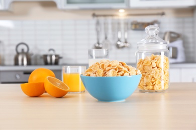 Cornflakes with glasses of juice and milk on kitchen table