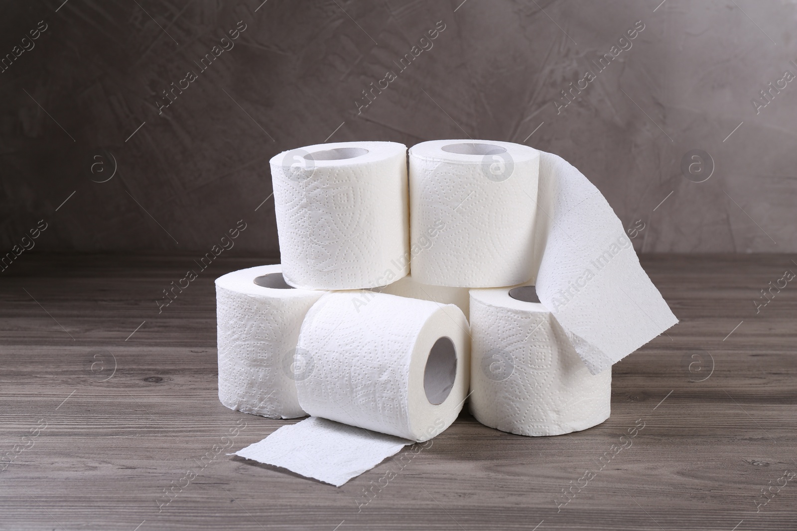 Photo of Soft toilet paper rolls on wooden table