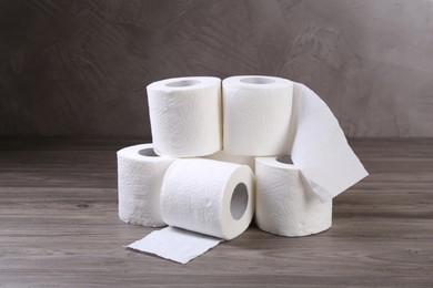 Photo of Soft toilet paper rolls on wooden table